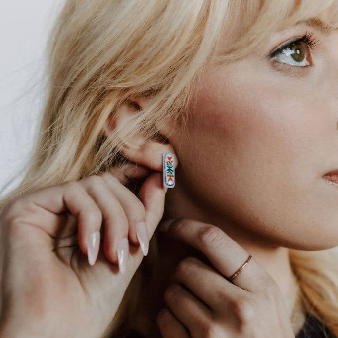 Handpainted floral ceramic stud earrings by Crown & Heart featuring colorful flower designs on small, decorative earrings.
