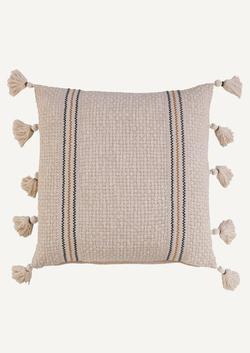 A natural cream colored pillow with weave texture, two zig zag stripes in black and ochre, and tassels at sides.