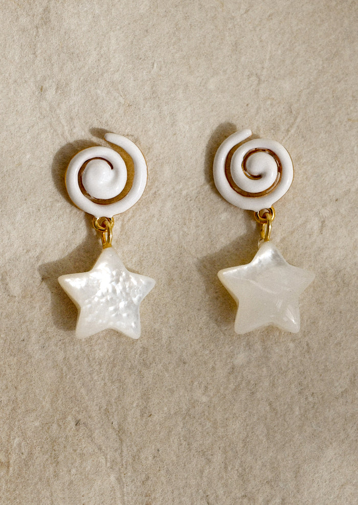 A pair of earrings with white swirl shaped enamel post and mother of pearl star charm.