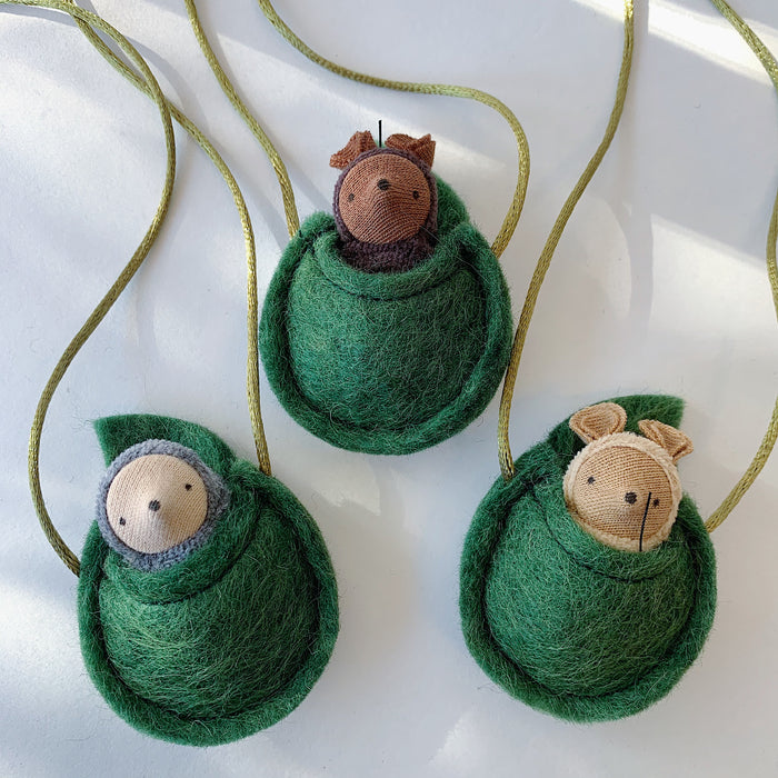 Fairy Shadow Critter Necklaces, overhead view of all three styles on a white surface, showing grey mole, chocolate mouse, and beige mouse critter figures peeking out of handmade felted green wool egg-shaped pouches on gold metallic cords