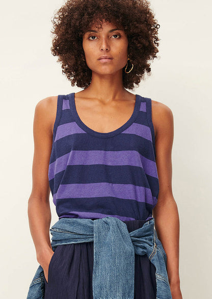 A woman wearing a scoop neck tank top in blue and purple stripes.