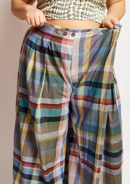 A woman wearing a pair of colorful multicolor check print wide leg pants.