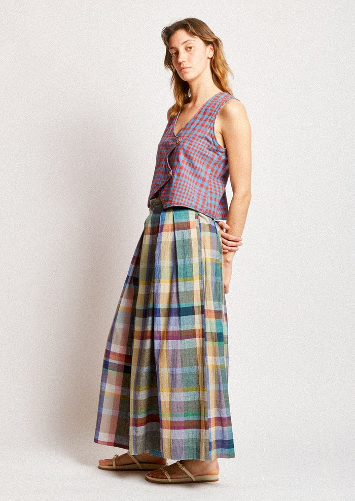 A woman wearing a pair of colorful multicolor check print wide leg pants.