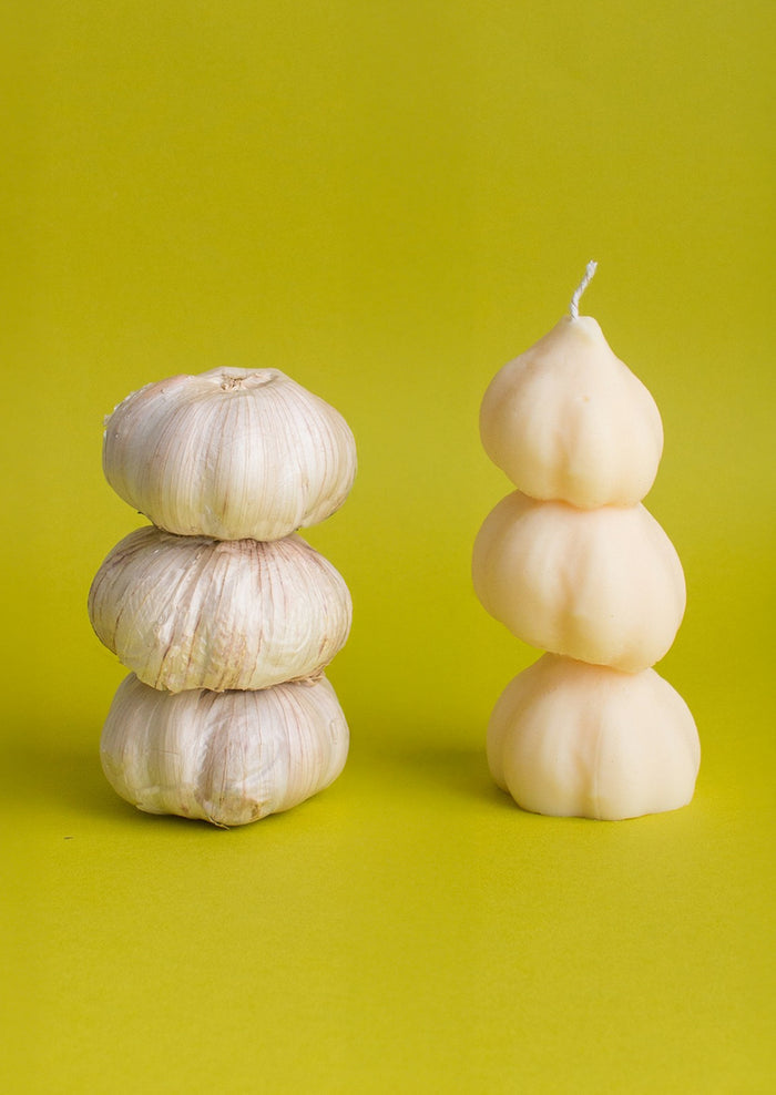 A candle in the shape of three stacked garlic bulbs.