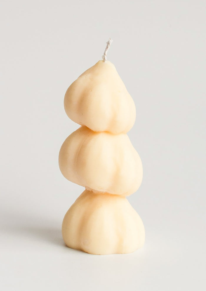 A candle in the shape of three stacked garlic bulbs.