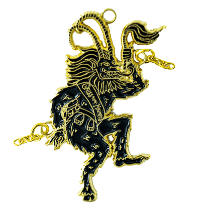 A black and gold ornament of Krampus sticking his tongue out and flailing his chains as he dances. He wears a sash that reads "Gross Vom Krampus".
