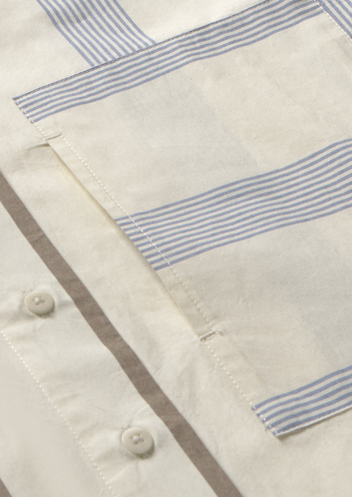 A button down collared shirt with half brown stripes, half blue stripes.