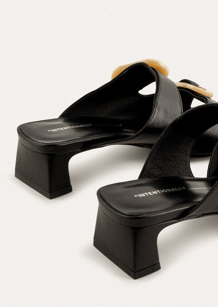 A square toe heeled sandal in black with double tan buckle detail.