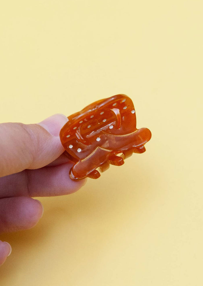A mini hair claw in shape of soft pretzel.