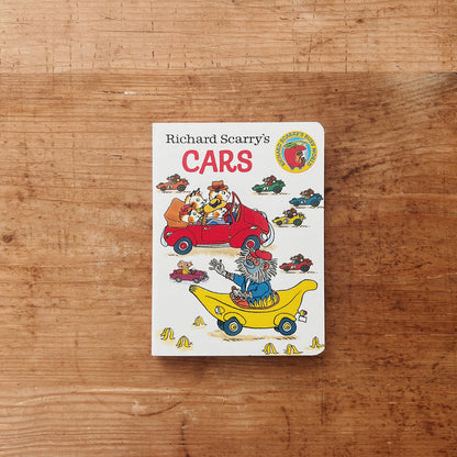 Cover of Richard Scarry's Cars board book featuring illustrated animal characters driving a red car and a yellow banana mobile, with colorful racing cars scattered across a white background