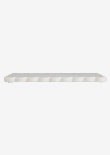 A white marble serving board with scalloped edge.