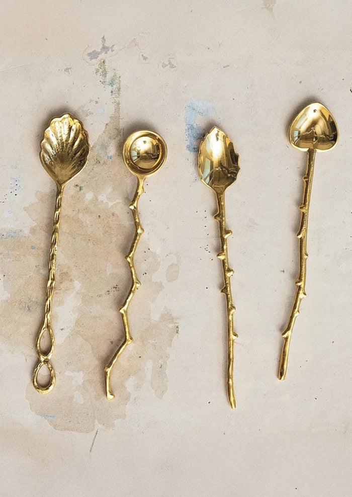 Assorted brass spoons in different shapes with twig-cast handles.