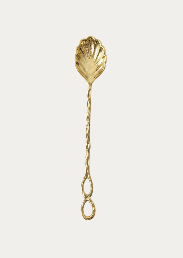 A brass spoon in shell shape.