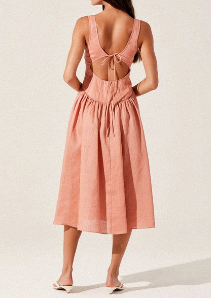 A woman wearing a peach colored corset bodice dress with full skirt.