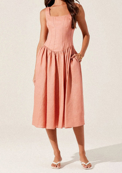 A woman wearing a peach colored corset bodice dress with full skirt.