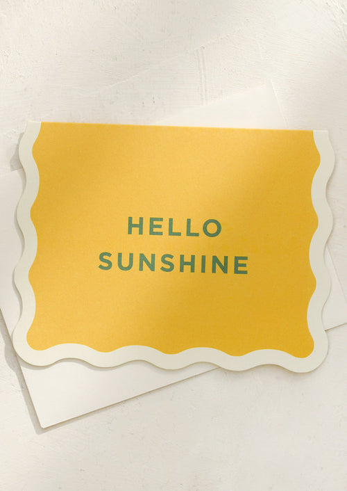 A yellow card with green lettering reading "Hello Sunshine".